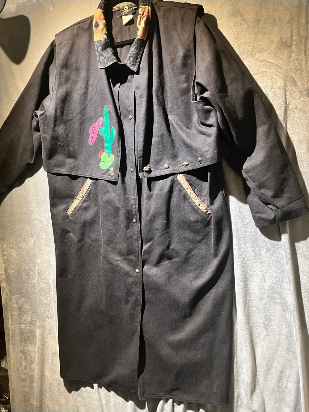 Black Long Trench Coat with attached snap vest. Embellishments on Vest. Sz M